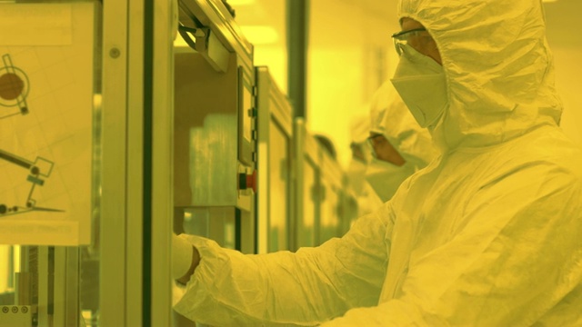 无菌高精密制造实验室，科学家在防护服的制造药理，电子，计算机设备。橙色的颜色视频素材