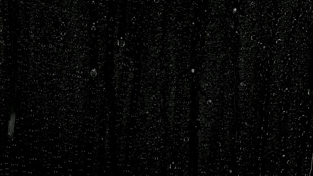 雨滴落在黑色的背景上。背景可以删除使用混合模式，如添加。视频下载