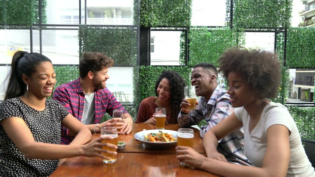一群朋友在酒吧里喝着啤酒，谈笑风生视频素材
