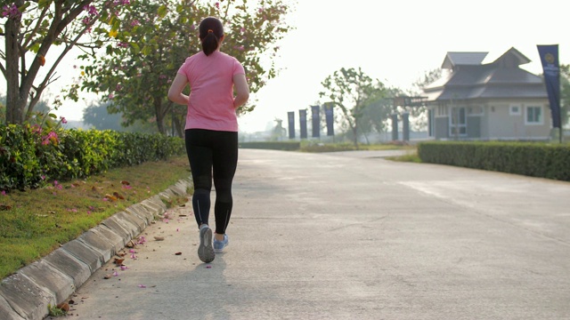 慢镜头:女人在公园里跑步做心脏运动视频素材