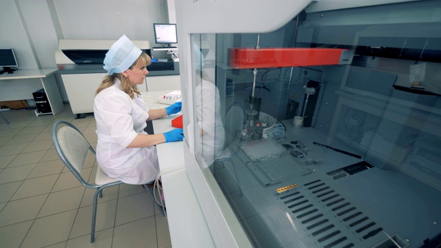 实验室配备生化分析仪和一位女性专家视频素材