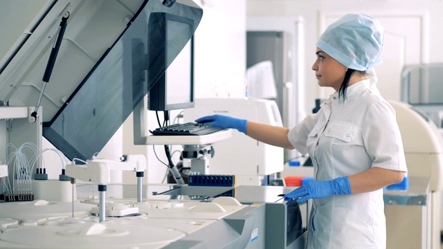 女性实验室专家管理自动化制药设备。视频素材