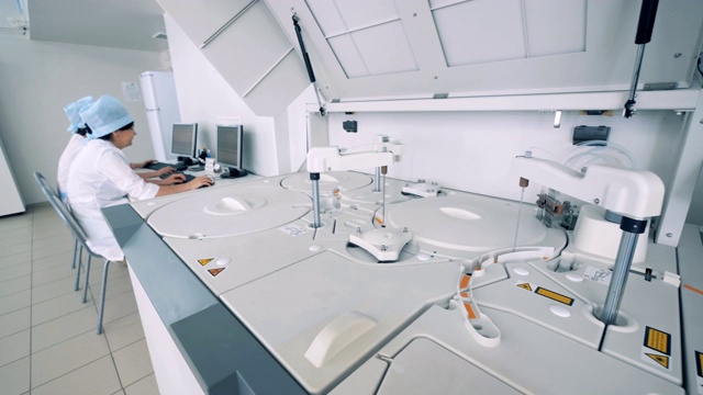 生化分析仪在工作与几个实验室专家在制药实验室。视频素材