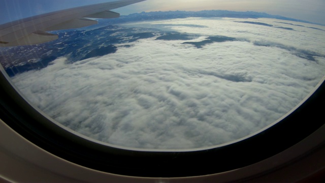 从飞机窗口看到的自然风光，有云雾、高山、雪峰视频下载