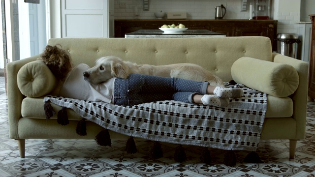 狗和女孩躺在沙发上视频素材