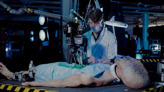 一位年轻的科学家在实验室里对一个外星人进行尸检。工作装置和传感器监视。视频下载
