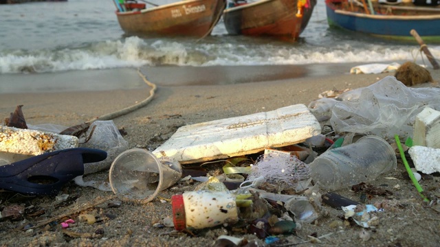 塑料瓶和其他垃圾在海滩上用摄影车拍摄。视频素材