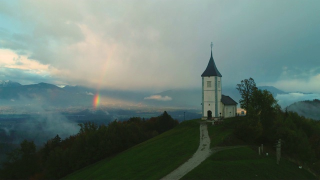 斯洛文尼亚萨瓦谷上游圣托马斯教堂的无人机拍摄。彩虹山景视频素材