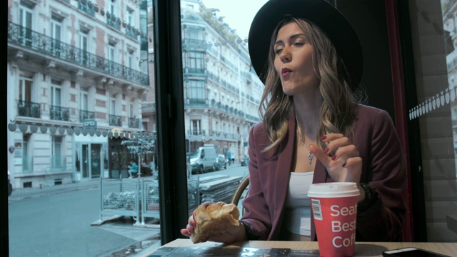 美丽的法国女人在吃牛角面包视频素材