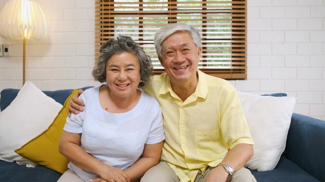 中拍亚洲老年夫妇在家里的客厅里与女儿和儿子进行视频通话。科技的生活方式。老在家里视频下载