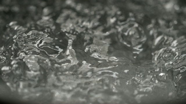 慢镜头，微距，DOF:一块冰落入一锅沸水中。视频素材