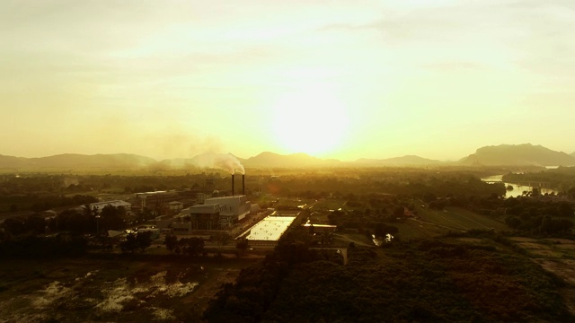 冒烟的工业，无人机拍摄的地平线上日落的剪影视频素材