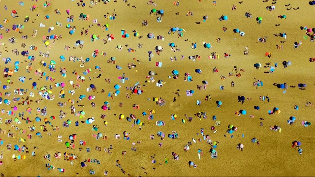 法国南部海滩上的海滩伞。有很多人在金色的沙滩上。视频下载