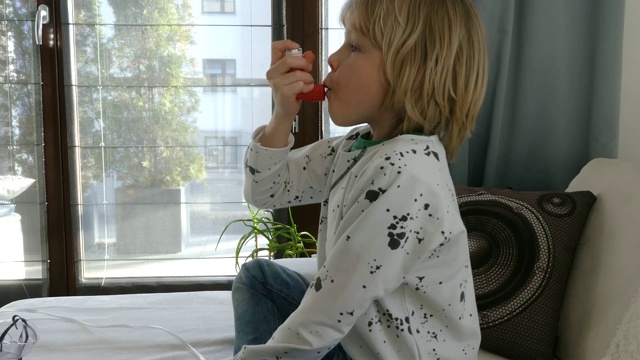 小男孩使用哮喘吸入器。视频下载