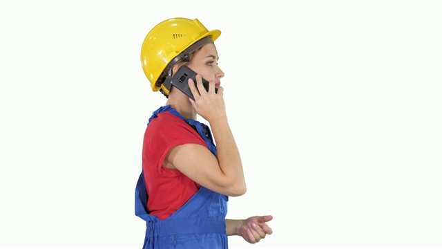 美丽的年轻建筑女工戴着黄色的安全帽在白色的背景下打电话视频素材