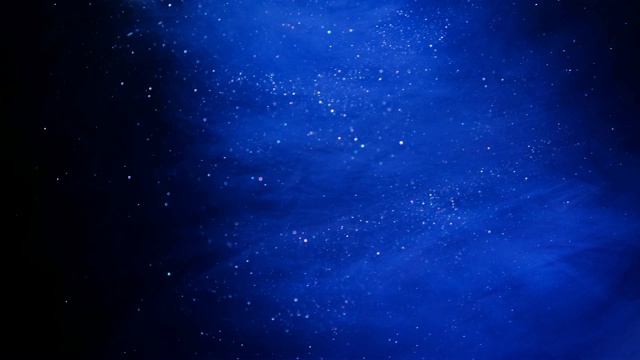 闪光蓝色粒子背景。宇宙的蓝色尘埃与星星在黑色的背景。粒子的运动抽象。视频下载