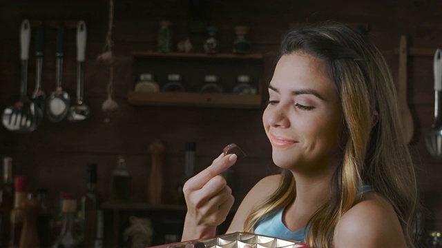 一个快乐的西班牙女人在一个乡村厨房吃放纵的巧克力的特写视频下载