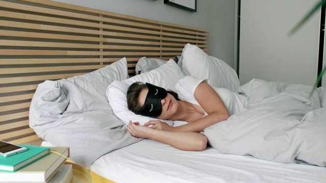 女人躺在她舒适的床上视频素材