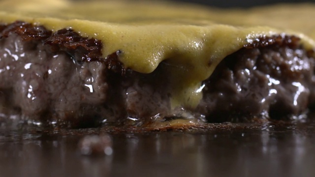 汉堡肉饼和奶酪在烤盘上烤视频下载