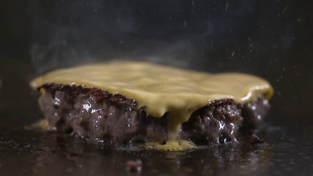 锅盖被打开，汉堡肉饼和奶酪被放在煎锅上烤视频下载