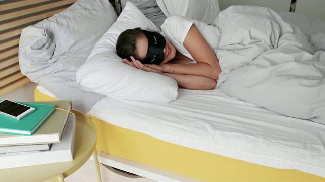 戴着眼罩睡在卧室里的女人视频素材
