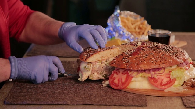 一个男人用刀切一个大汉堡视频下载