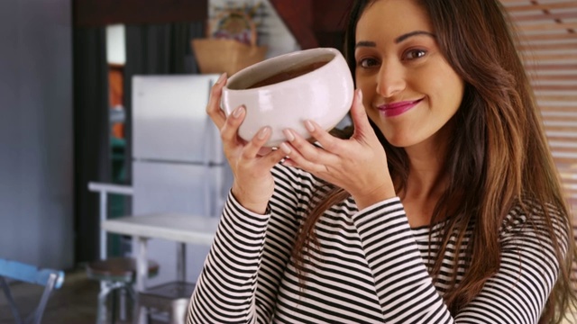 欢快的拉丁女性举着陶瓷碗，对着镜头微笑的肖像视频下载