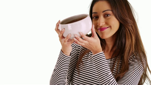 一个拉丁女性的肖像，举着陶瓷碗，对着相机微笑在工作室视频下载
