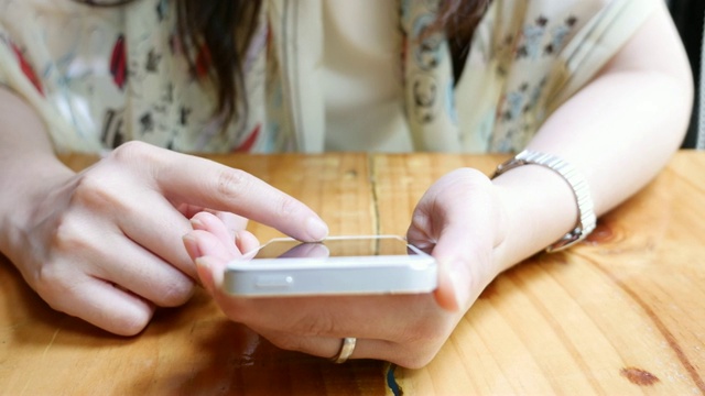 近距离女人的手使用智能手机在咖啡馆视频素材