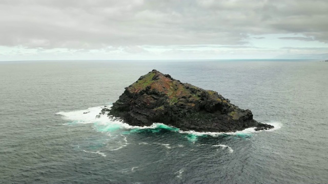 空中射击。在蓝色的海水中冰冻的火山熔岩的石头岛。上面有个天主教十字架。加拉奇科，特内里费，加那利群岛视频素材