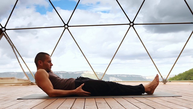 瑜伽练习:男人仰面躺着伸直双腿视频素材