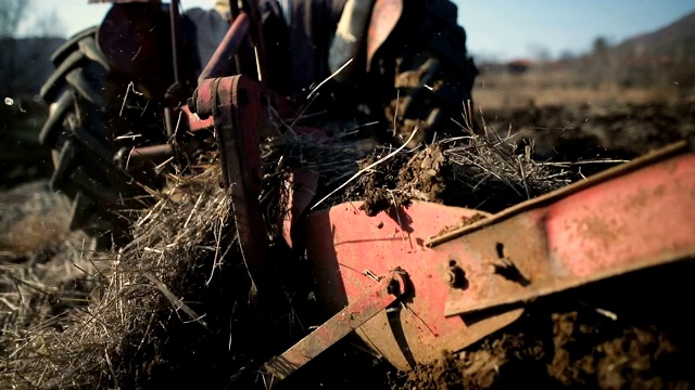高级男子驾驶小型拖拉机和耕地。农业活动视频下载