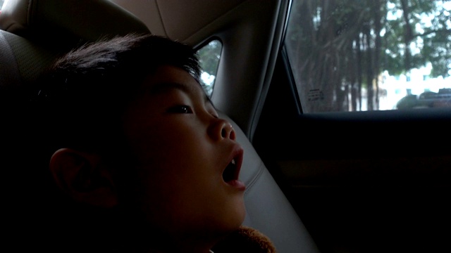 亚洲男孩在车里打哈欠视频素材