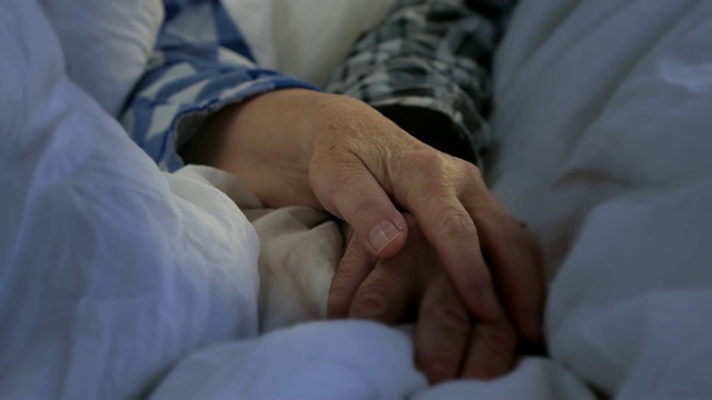 老夫妇手牵着手躺在床上视频素材