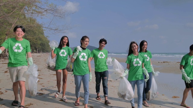一群快乐的志愿者用垃圾袋清理海滩上的区域。志愿、慈善、清洁、人与生态的观念视频素材