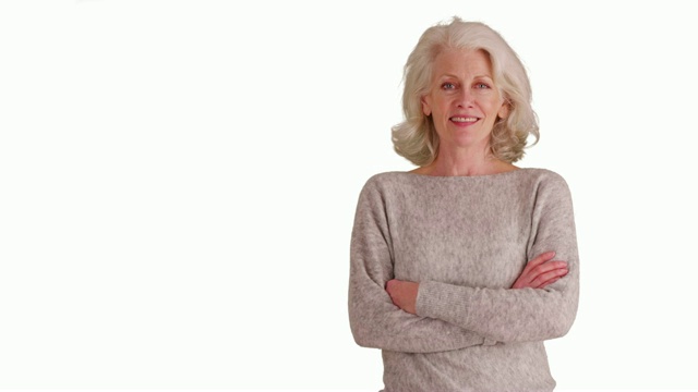 可爱的老妇人在灰色毛衣微笑在白色的背景与拷贝空间视频下载