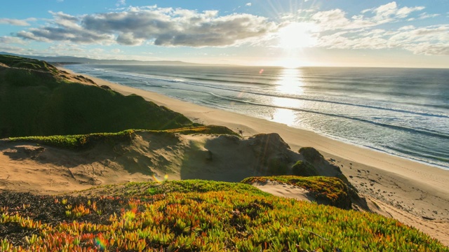 时间流逝:海边长满草的沙丘与地平线上的日落视频素材