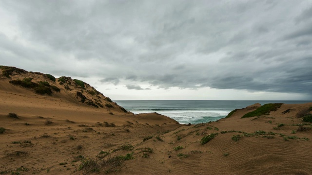 时间流逝:暴风雨的灰色云经过沙丘和海浪充满海洋视频素材
