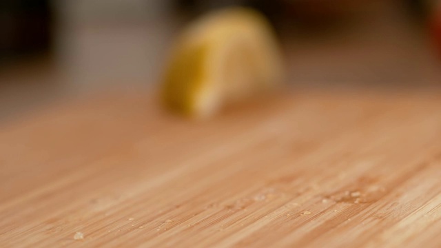 MACRO:柠檬片掉在木板上，酸汁溅在木板表面视频素材