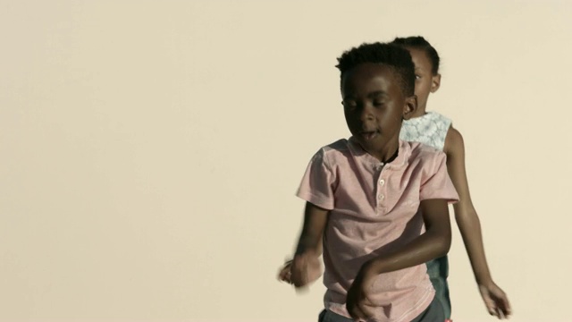 男孩和女孩在米色的背景下跳舞视频素材