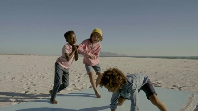 男孩们在海滩上跳舞玩耍视频素材