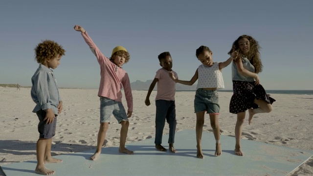 女孩和男孩在海滩上对着天空跳舞视频素材
