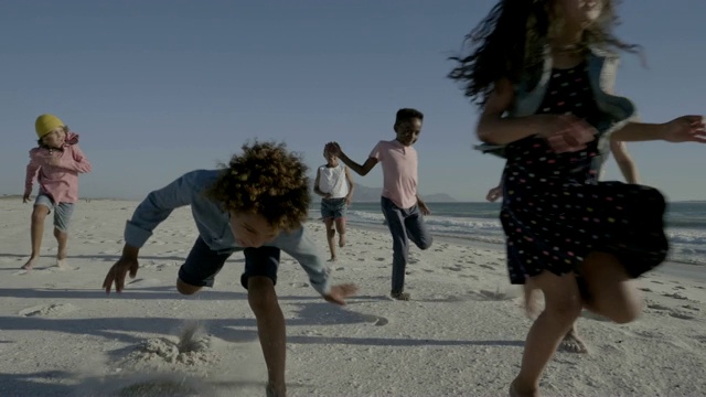 孩子们迎着天空在海滩上奔跑视频素材