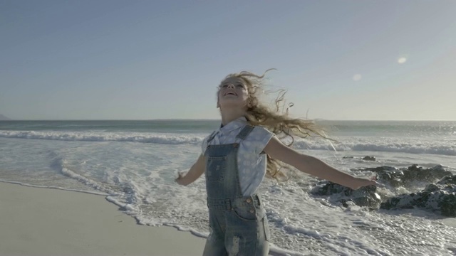 女孩在沙滩上旋转，男孩在沙滩上奔跑视频素材