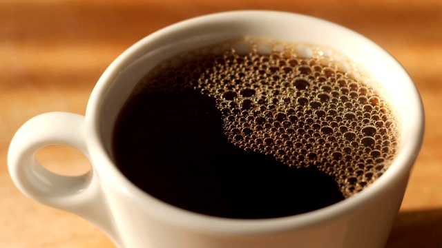 将黑咖啡倒进带有天然蒸汽和气泡的杯子里视频素材