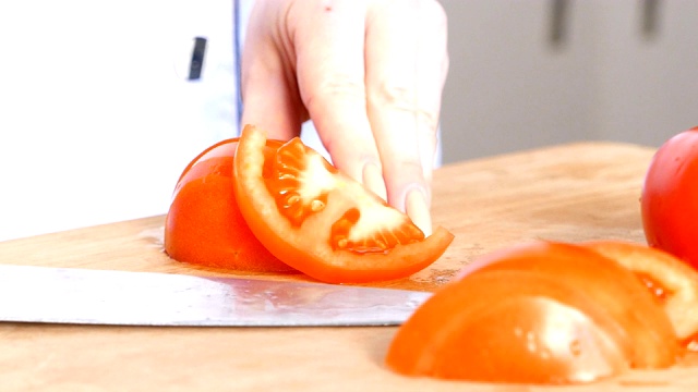 女厨师切新鲜的西红柿，手特写视频素材
