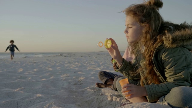 可爱的孩子们在海滩上吹肥皂泡视频素材