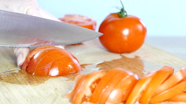 女厨师切新鲜的西红柿，手特写视频素材