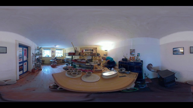 360 VR /一个陶工在她的工作室里制作一个杯子视频素材