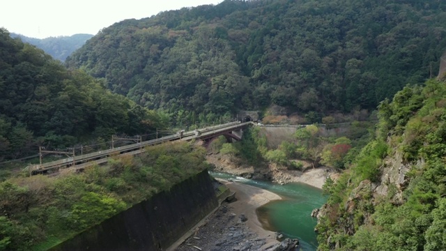 鸟瞰图Katsura河和铁路附近的岚山京都日本。岚山位于日本京都的西部，在樱花和秋叶季节是非常受欢迎的旅游目的地。视频素材